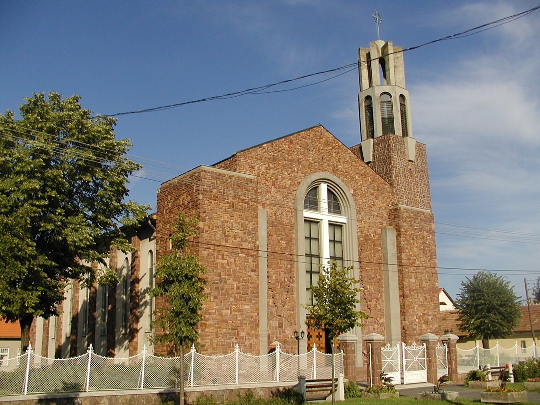 A vöröskőből épült római katolikus templom utcafronti homlokzata.